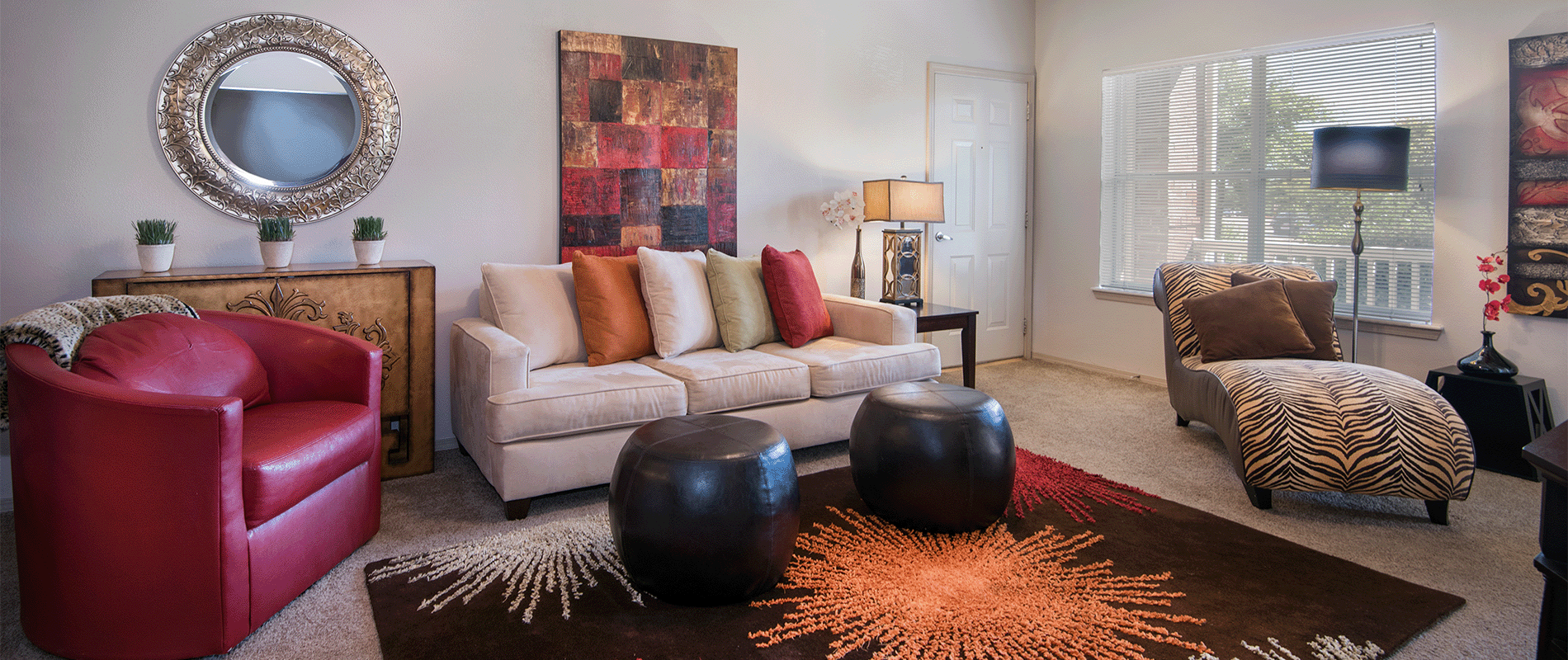 a living room with a couch and a chair and a mirror